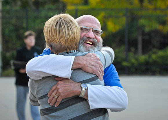 charlie smiling and hugging staff member on campus