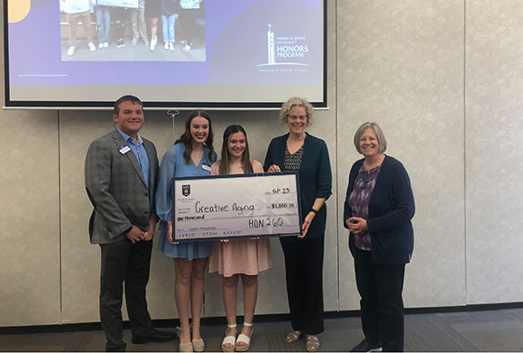 student philanthropy group holding check