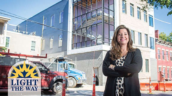 Mount St. Joseph University alumna danielle armrine with arms crossed smiling outside organization