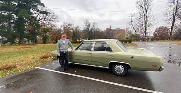 Mount St. Joseph University professor jim bodle standing by vintage car.