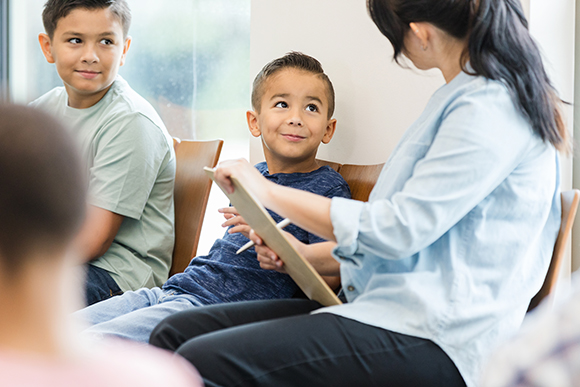 little kids looking at woman who is a social worker 