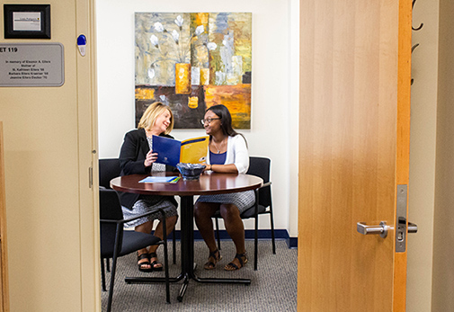 Career Center staff member assisting student in office.