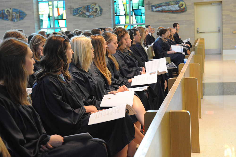 students at baccalaureate reading their programs.