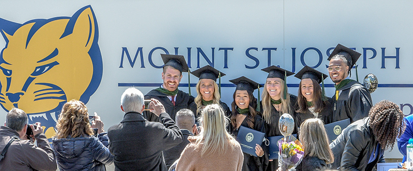 students smiling getting photos taken for commencement