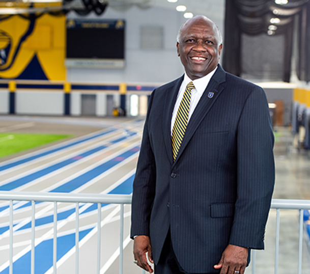 President H. James Williams standing in centennial field house.