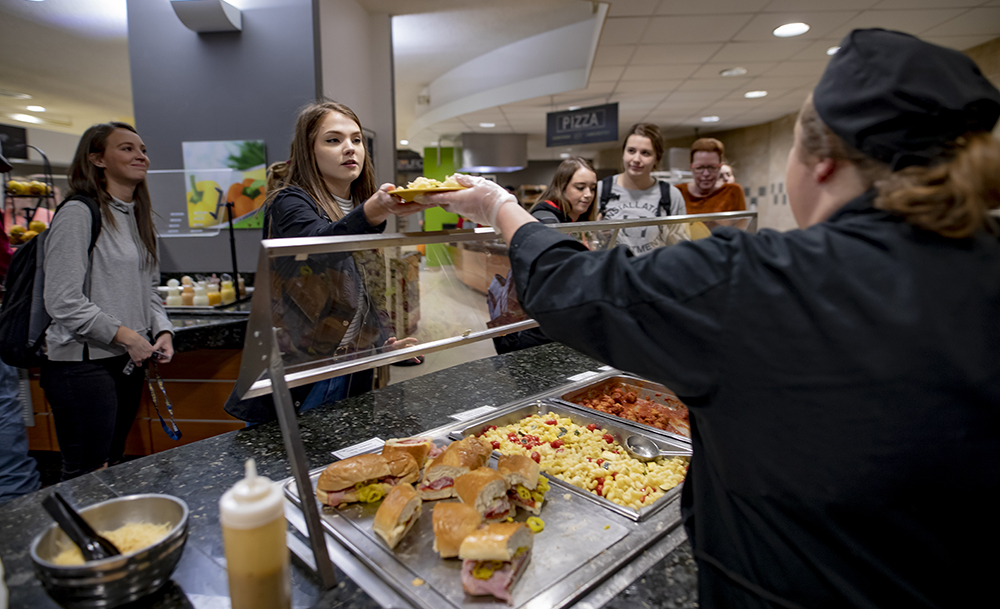 student grabbing food in dining hall