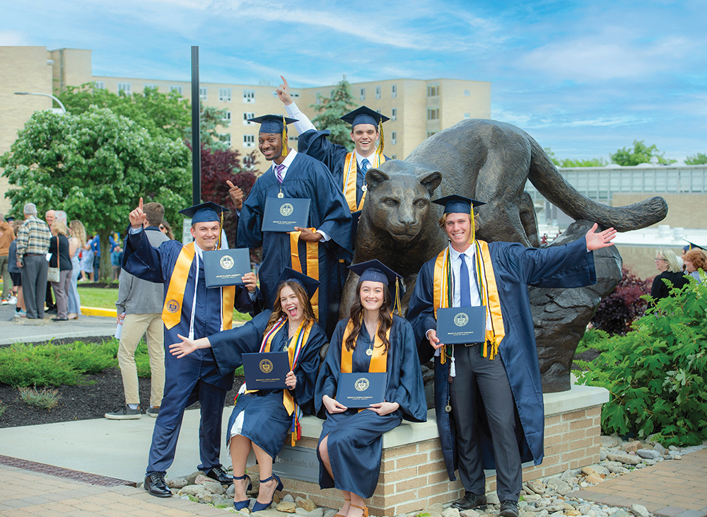 students by catamount statue at graduatino