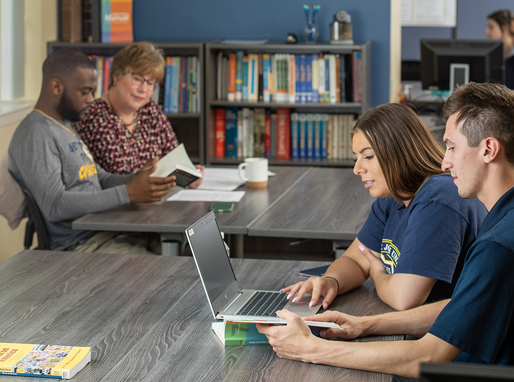 students looking at laptop in learning center