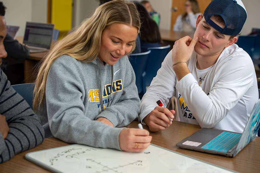 two msj students working on project at desk