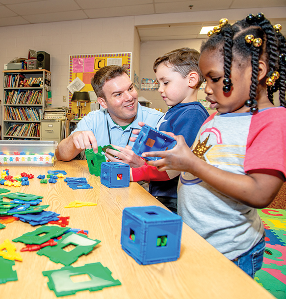 teacher playing with blocks with elementary kids.