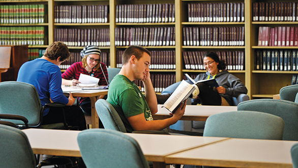 liberal arts students sitting in library reading textbooks.