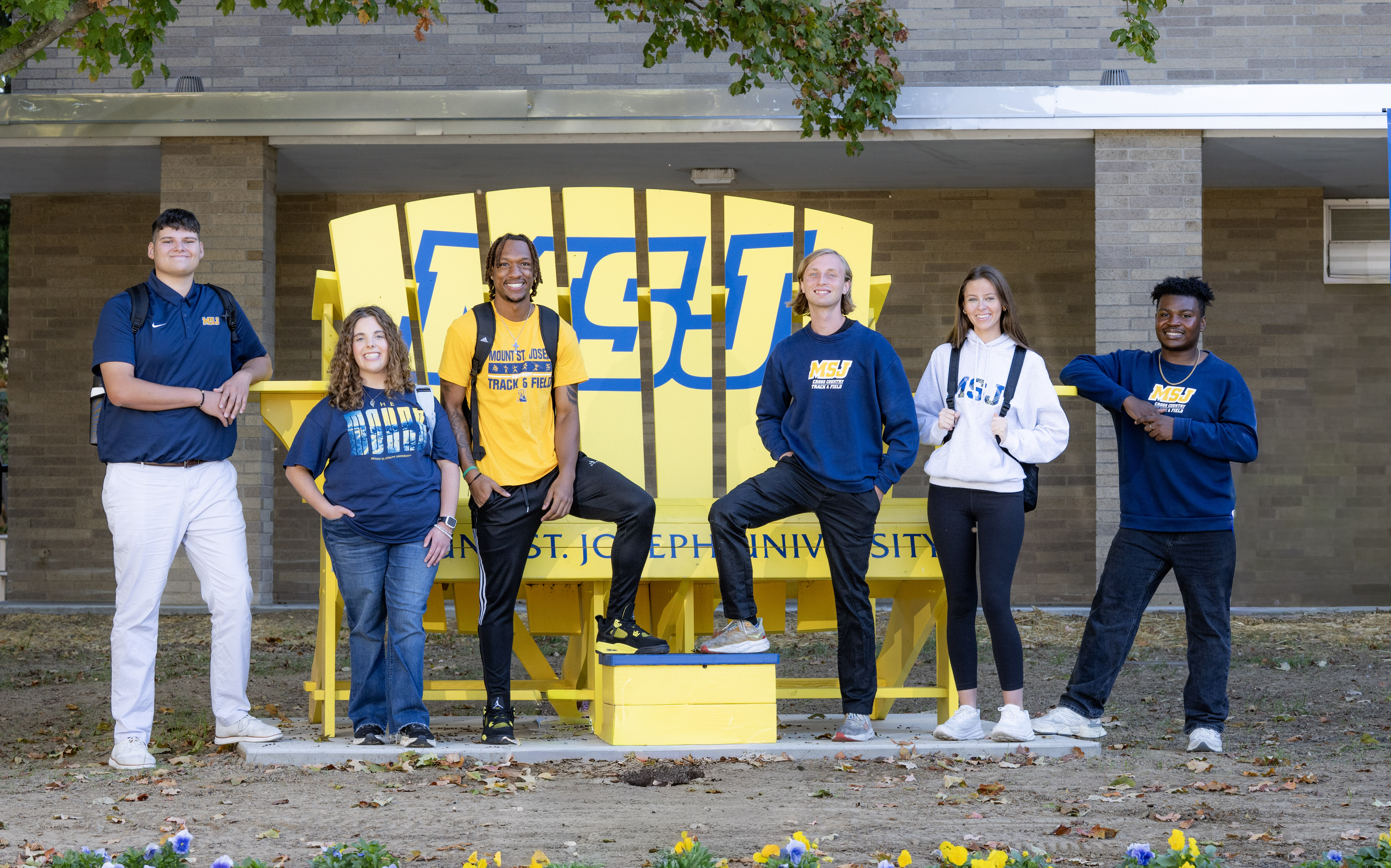 students in yellow chair smiling next to each other