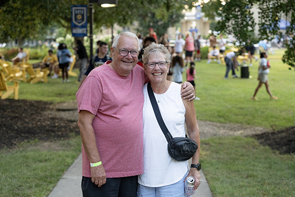 a man and woman standing next to each other smiling