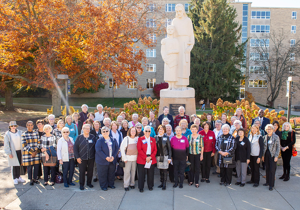 50th reunion female alumni group gathered by st. joseph statue.