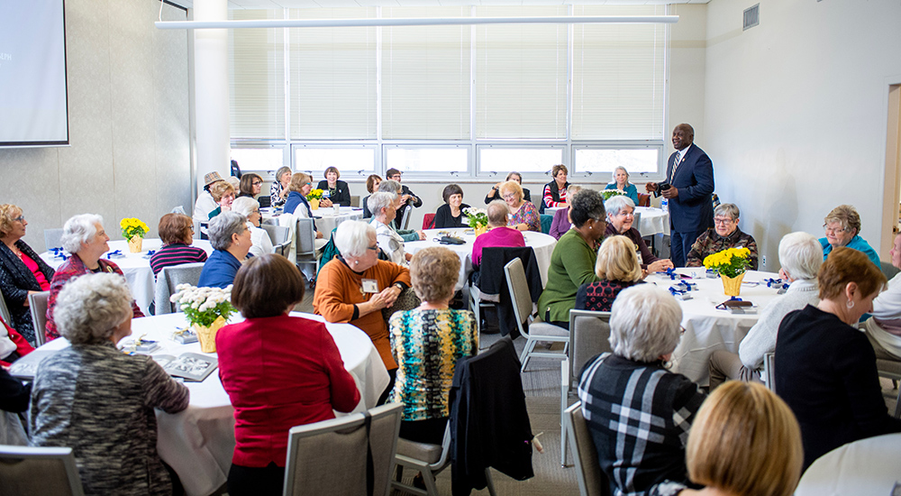 50th reunion female alumni gathered in dining hall with president williams