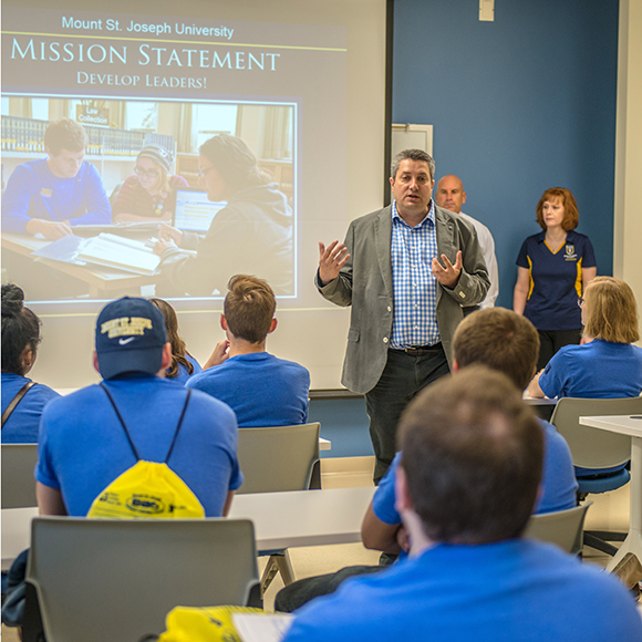 faculty member presenting to students in classroom.
