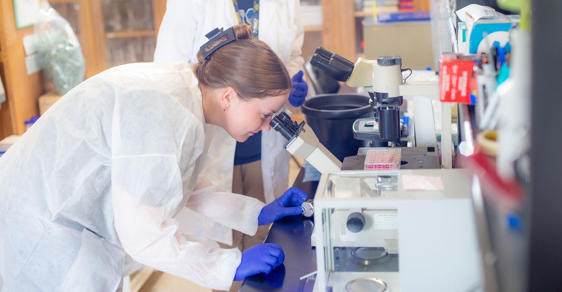 biology students in white coats holding flasks