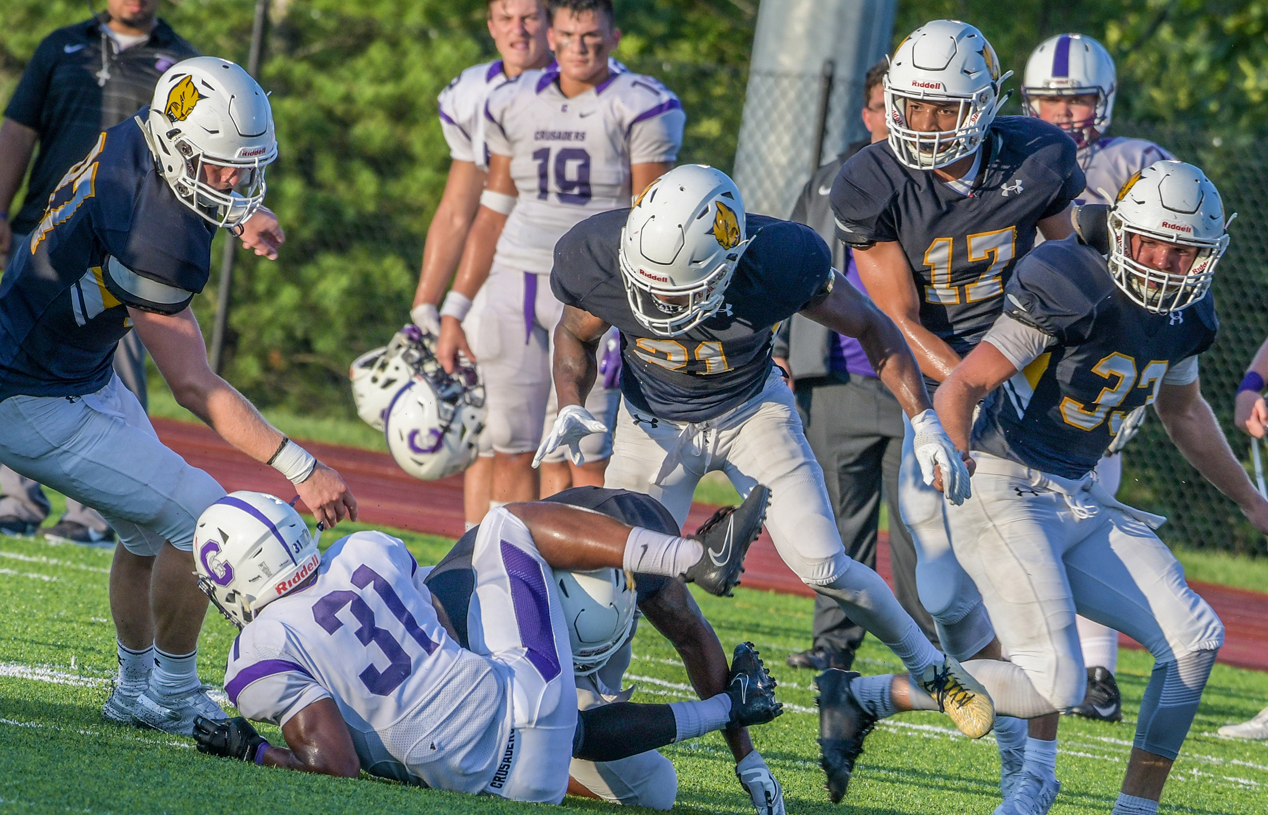 MSJ football players tackling on field