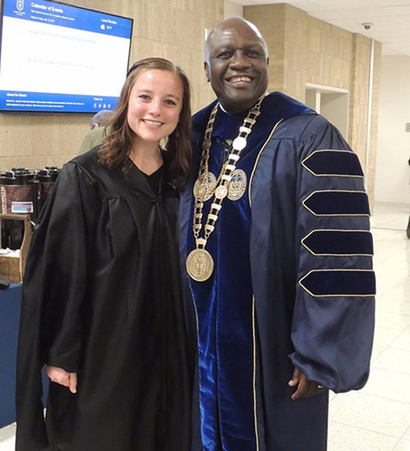 graduate standing next to president h. james williams