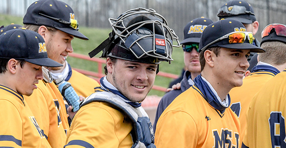 Mount St. Joseph University baseball players smiling on field.