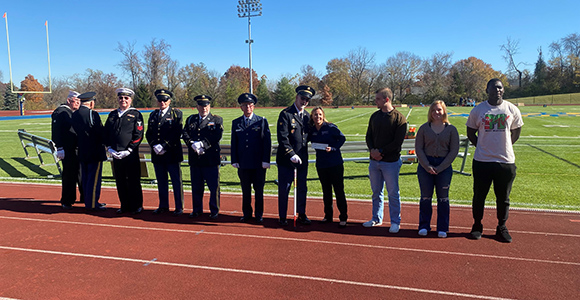 Mount St. Joseph University veteran students on field receiving scholarship award