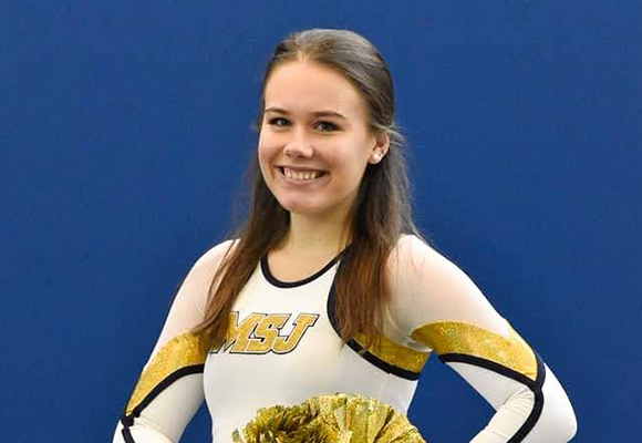 Mount St. Joseph University Resident Assistant Jetta McCart smiling in MSJ cheer uniform.