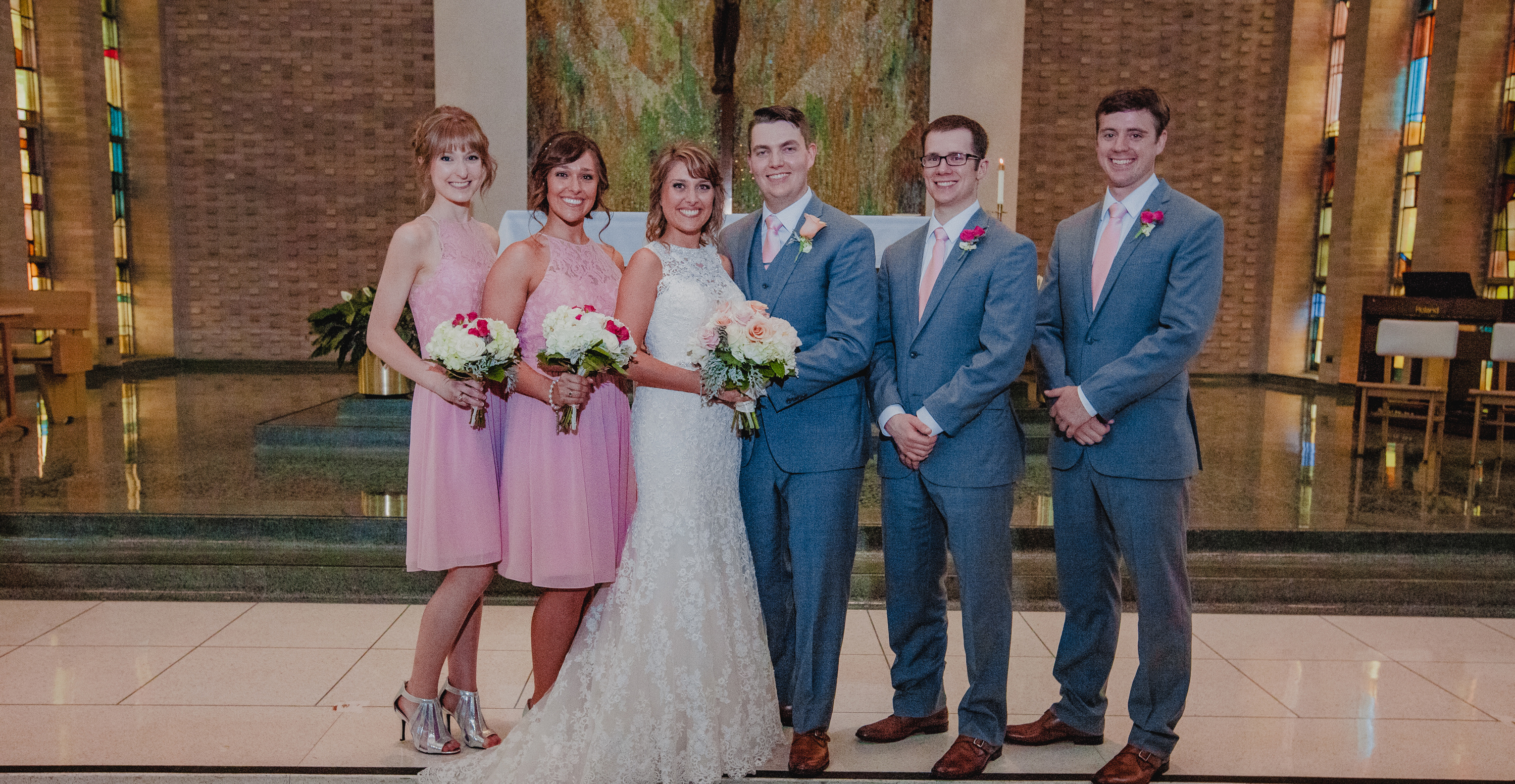 msj alumni kelsey and miles in mater dei chapel with alumni wedding party.