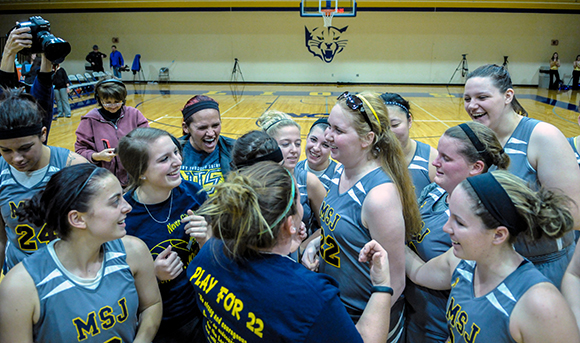 women's basketball team gathered around lauren hill