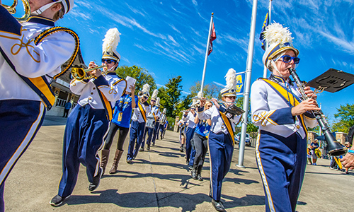 MSJ marching band marching by schueler field.
