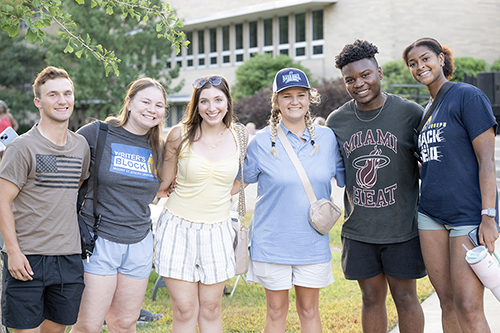 students smiling next to each other outside