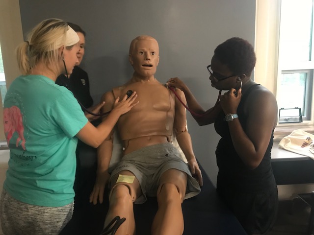 Photo of Physician Assistant students using of technology for heart auscultation.