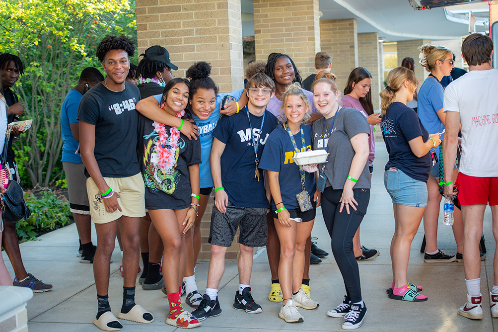 students standing by food truck smiling