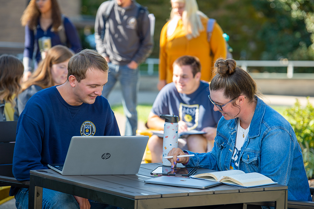 MSJ students sitting in quad doing homework.