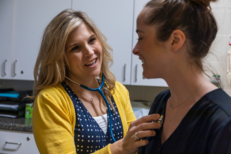 MSJ female student getting examined by female nurse in MSJ Wellness Center.