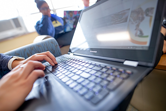 student on laptop using financial aid net price calculator