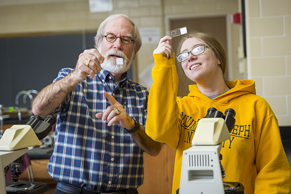 professor and student looking at scientific instruments